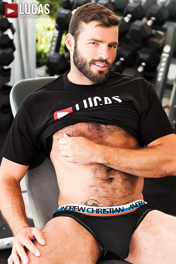 Xavier Jacobs, gay porn otter, plays with his nipple in Lucas Entertainment t-shirt